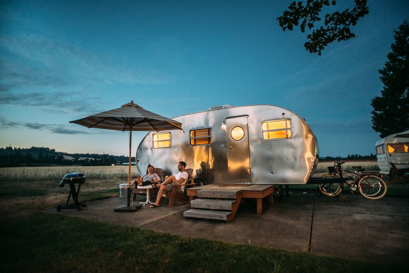 Guests outside an RV at dusk